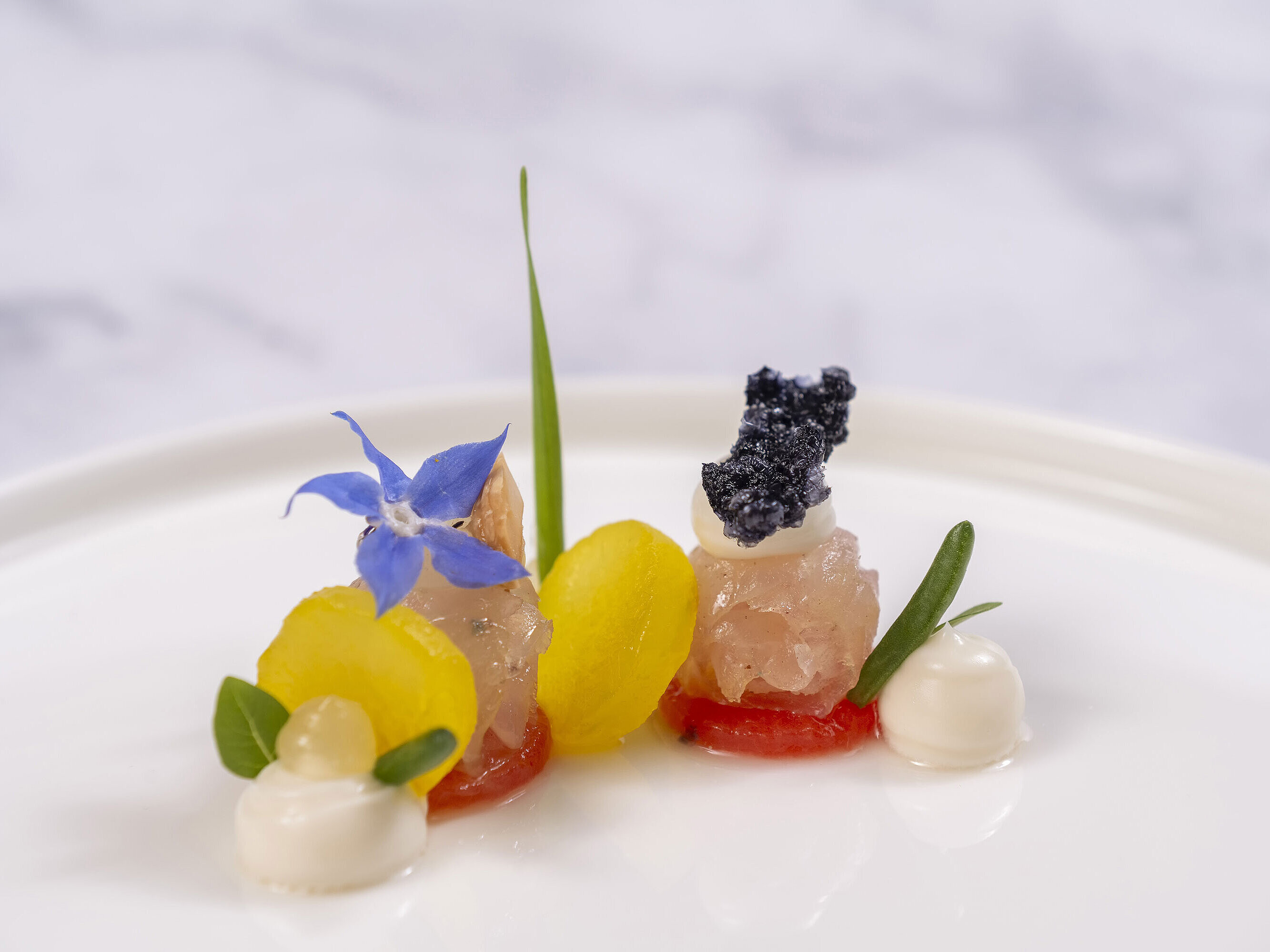Feines Amuse-Bouche mit Kaviar und Blüten, serviert in der Orangerie im Maritim Timmendorfer Strand.