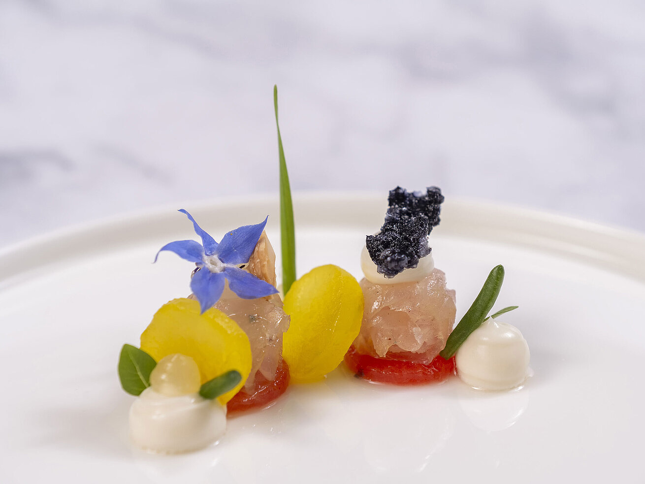 Gericht Feines Amuse-Bouche mit Kaviar und Blüten, serviert in der Orangerie im Maritim Timmendorfer Strand.