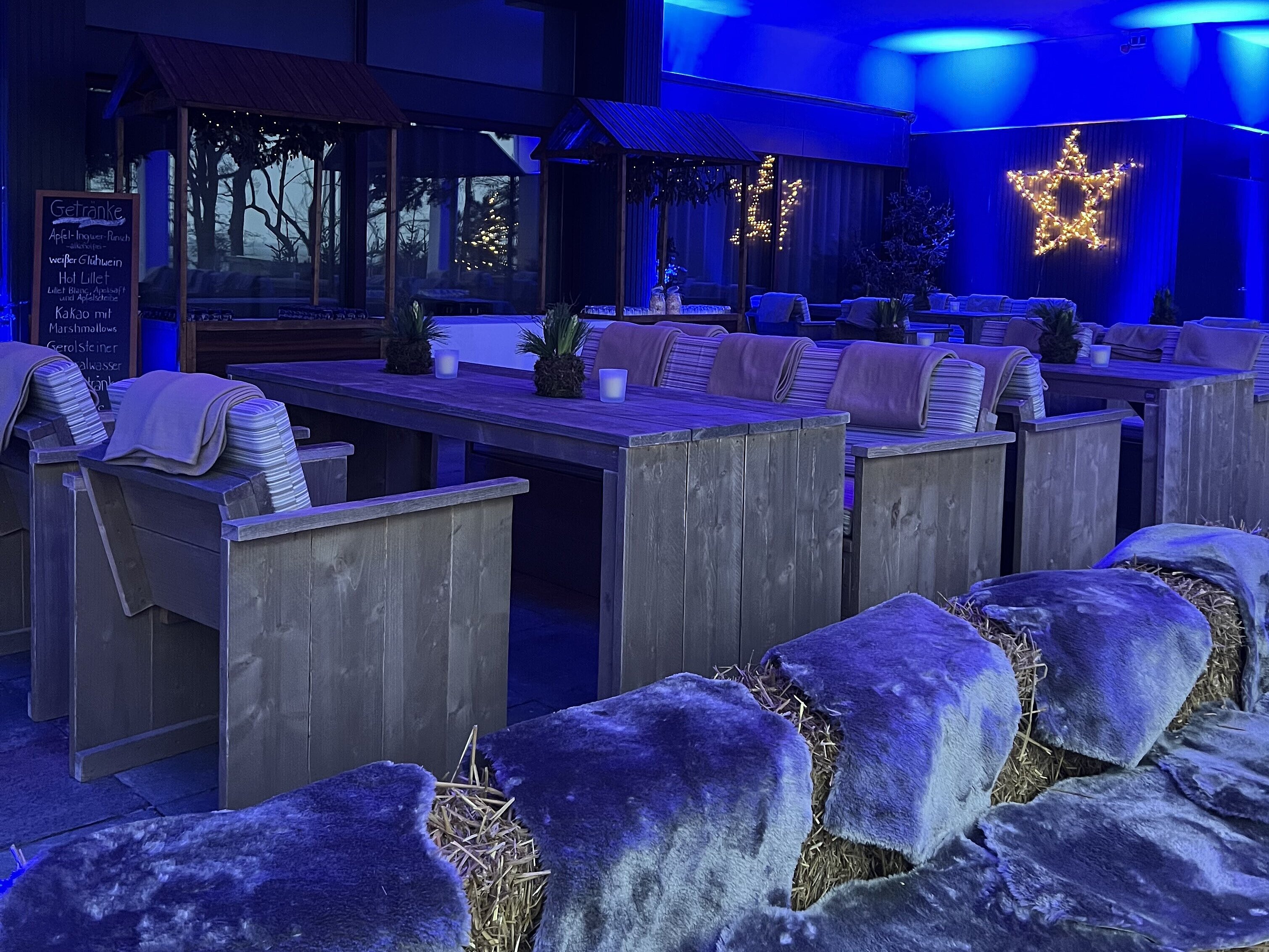 Festlich beleuchtete Winterterrasse mit Holzmöbeln, Fellen und Sternendeko im Maritim Seehotel Timmendorfer Strand.
