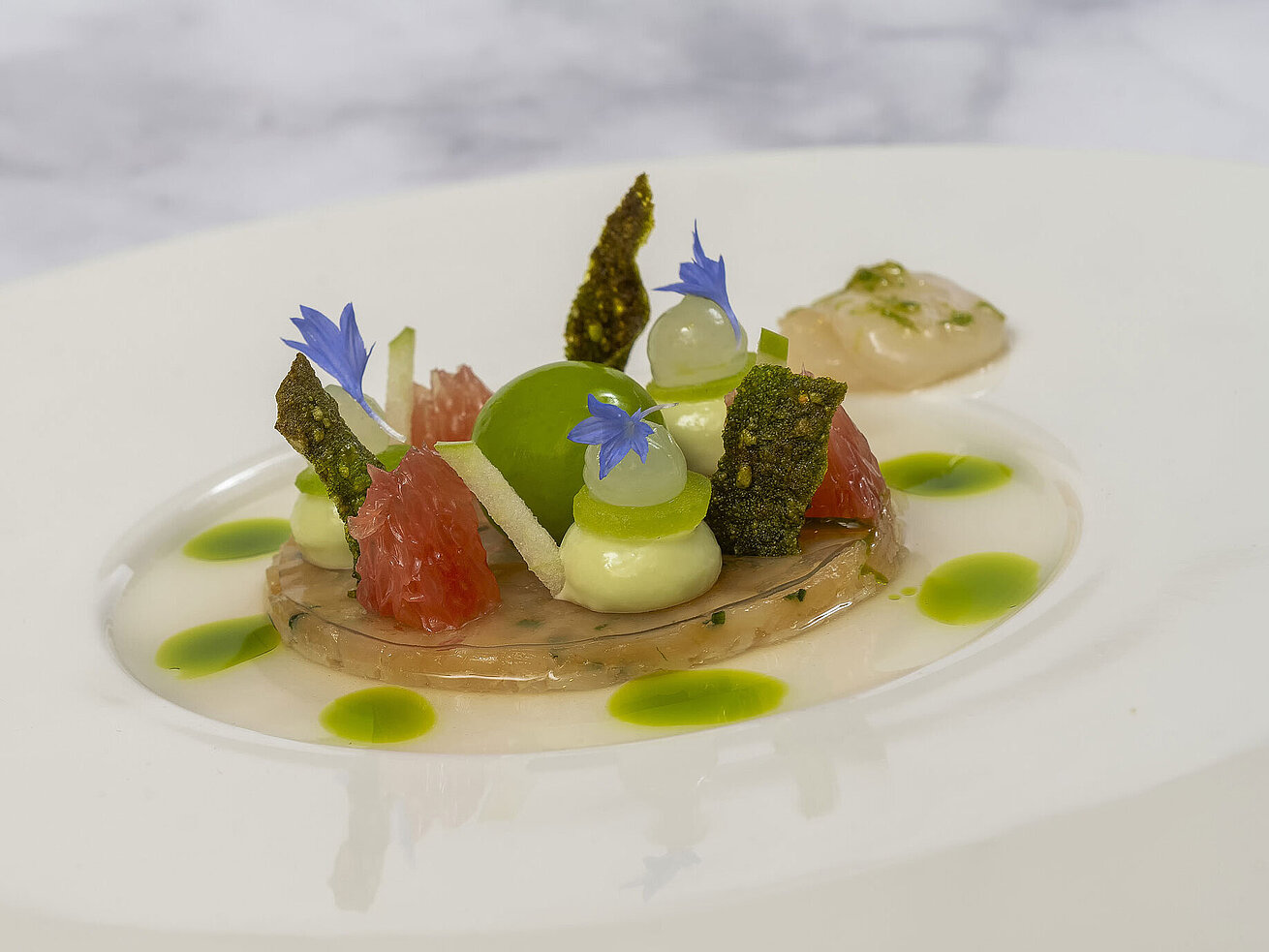 Gericht mit Jakobsmuscheln und kunstvoller Präsentation in der Orangerie im Maritim Hotel Timmendorfer Strand.