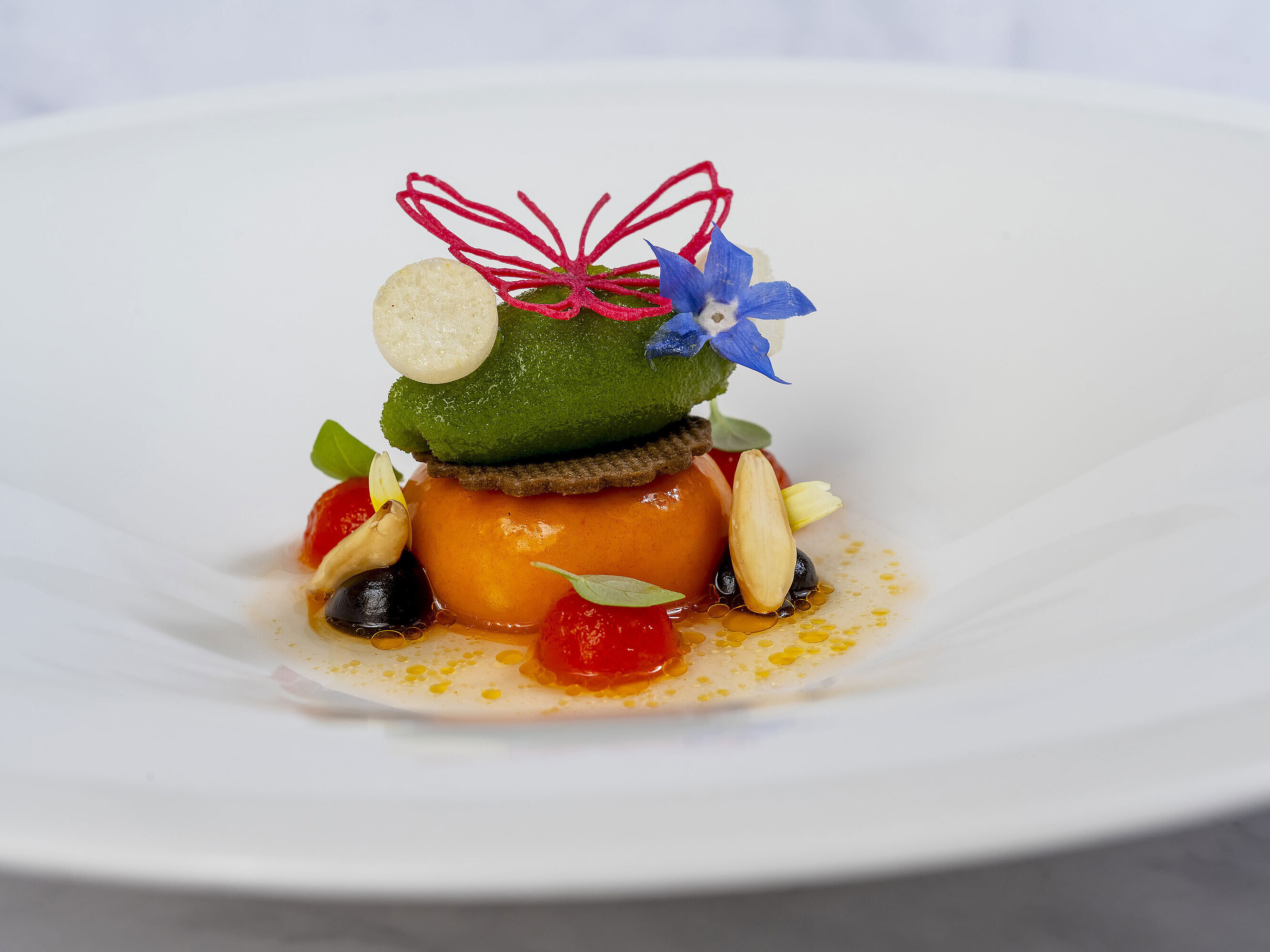 Dessert: Frische Früchte, zartes Sorbet und ein Schmetterling aus Zucker, der an die Schönheit der Natur erinnert.